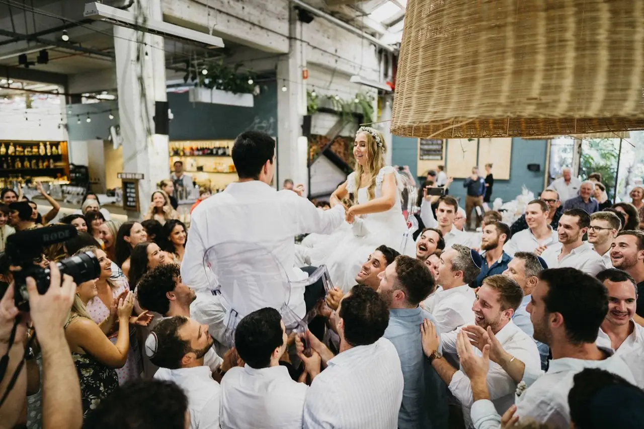 Tali & Jesse at Three Blue Ducks: Guests gather closely around the celebrating couple.