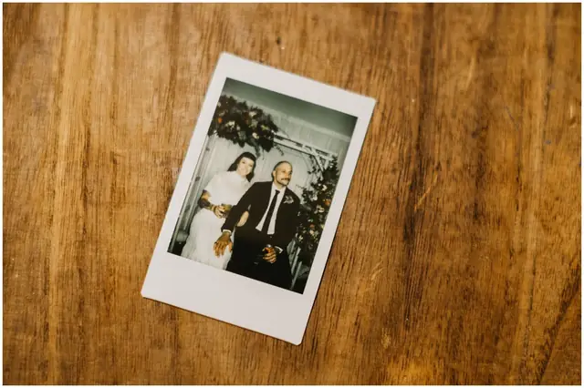 Luke & Cara at Cowbell Creek: An instant photograph of the couple rests on a wooden table.