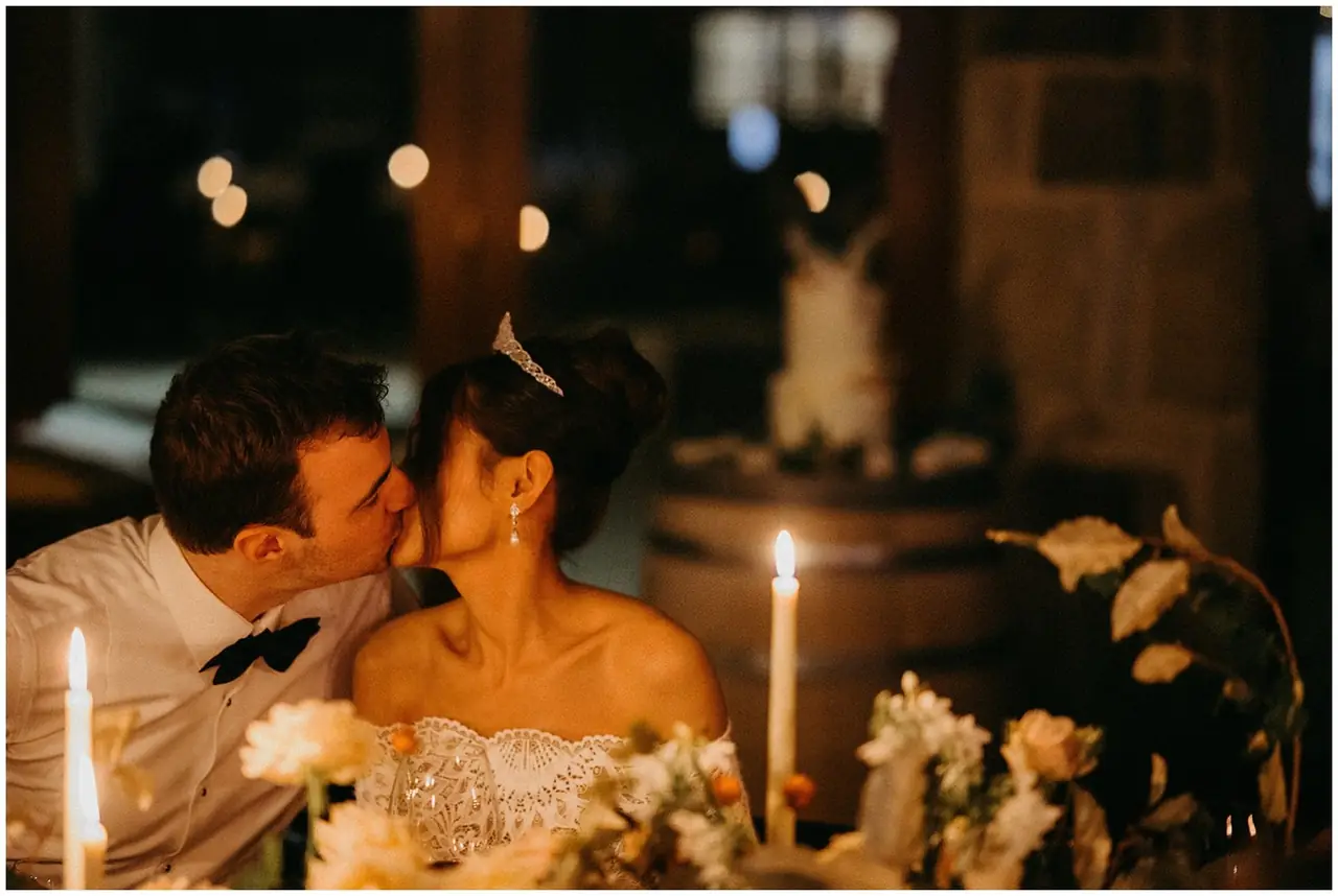 Tom & Josslyn at Emirates One&Only Wolgan Valley: The couple share a kiss at the candlelit reception table.