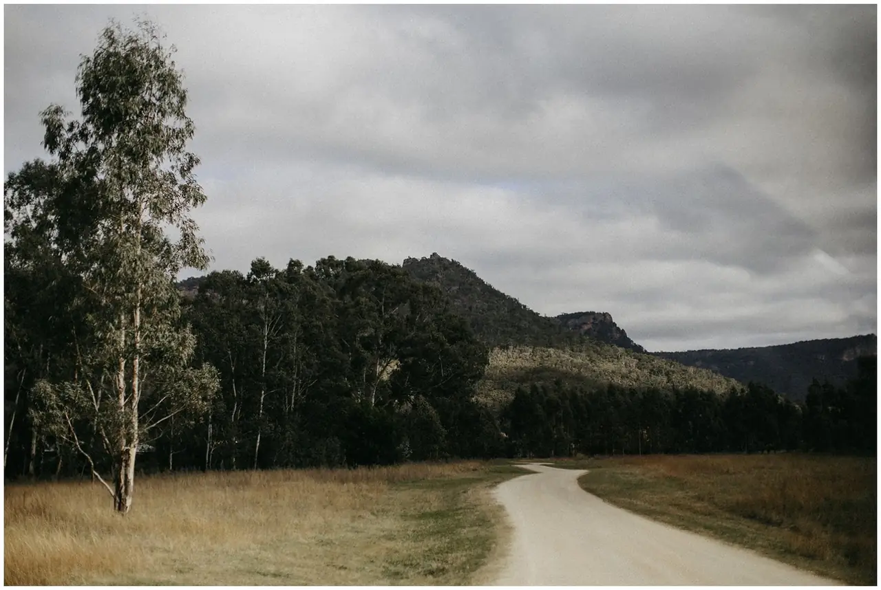 Tom & Josslyn at Emirates One&Only Wolgan Valley: A winding road runs through the valley beneath sandstone cliffs.