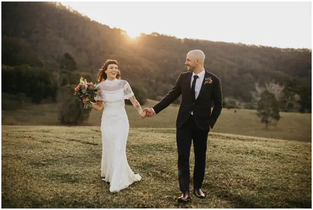 Luke & Cara at Cowbell Creek: The couple hold hands as they walk across the grass.