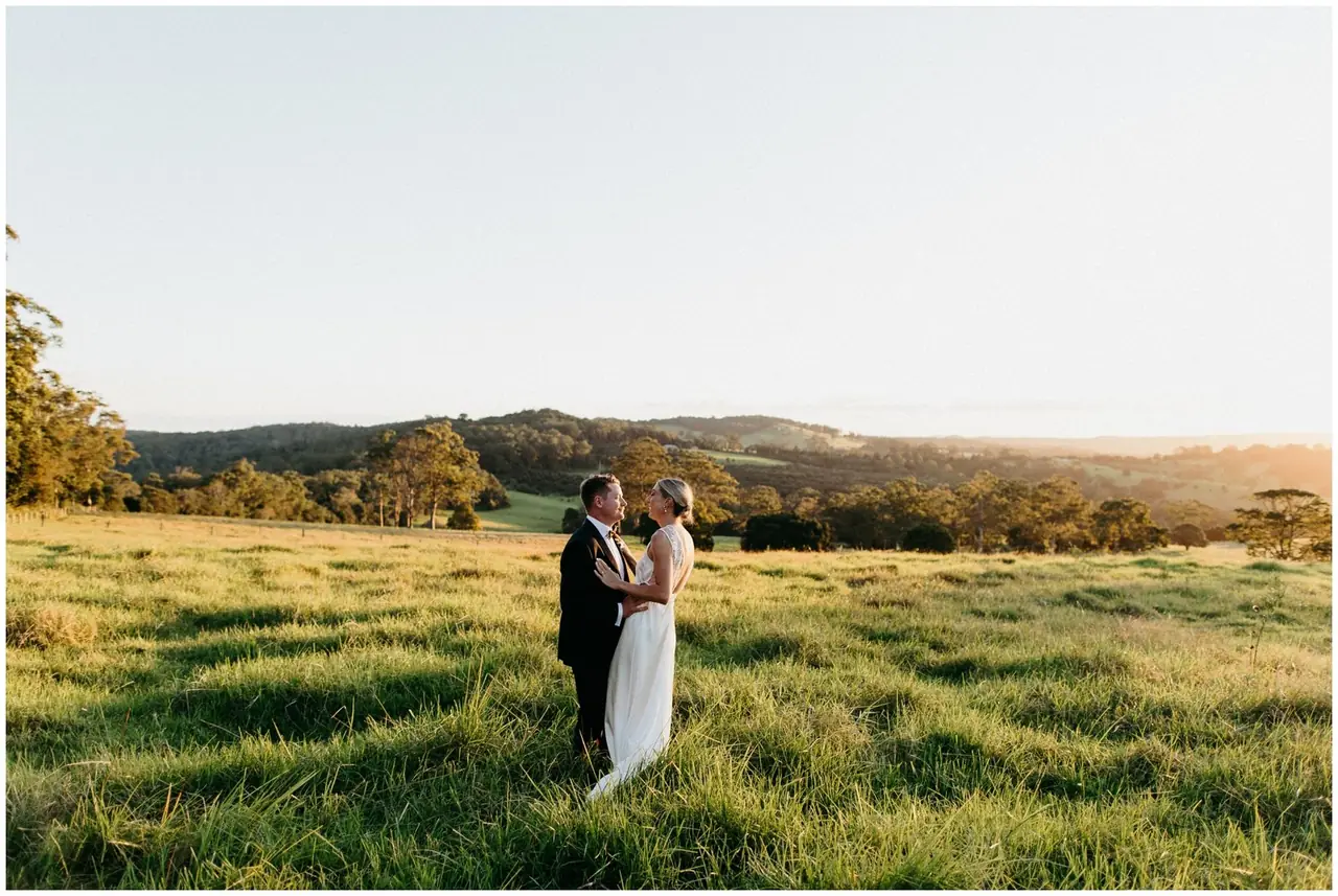 Ella & Jackson at The Woods: The couple embrace in a paddock as the light softens.
