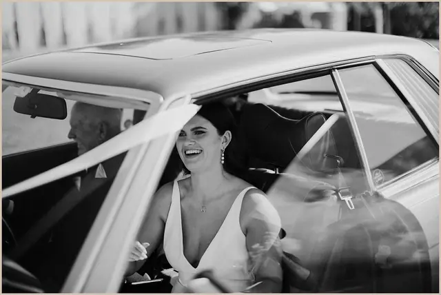 Jess & Rich at The Orchard Estate: The bride smiles from inside the wedding car.