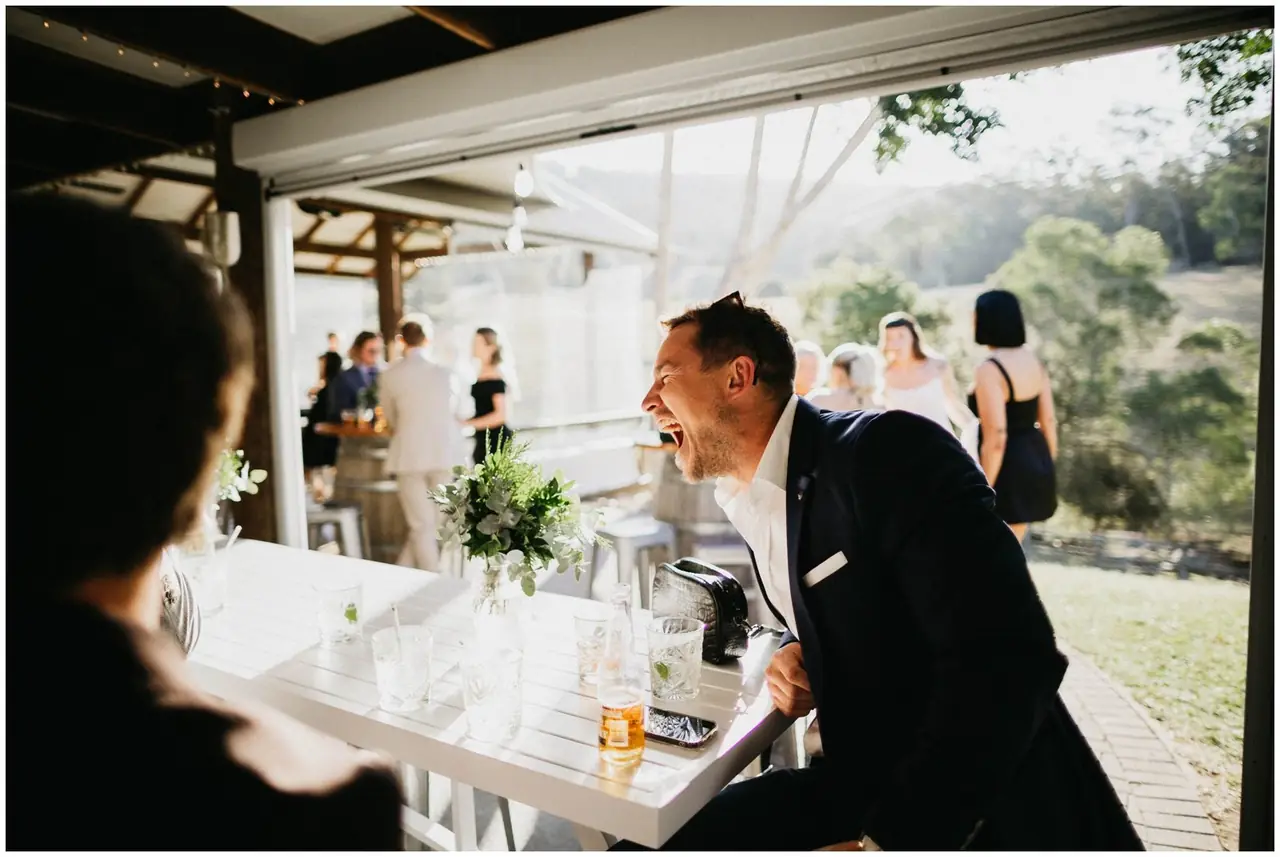 Luke & Cara at Cowbell Creek: The groom smiles across the reception table.