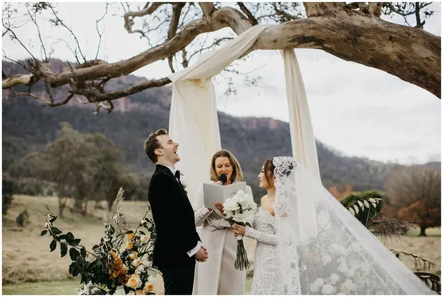 Tom & Josslyn at Emirates One&Only Wolgan Valley: The couple stand beneath fabric draped from a tree at their ceremony.