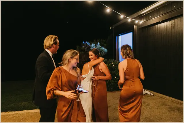 Jess & Rich at The Orchard Estate: Guests dance together beneath lights after dark.