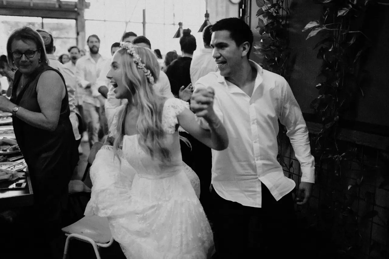 Tali & Jesse at Three Blue Ducks: The couple smile together among their guests, in black and white.