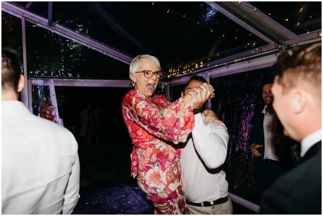 Ella & Jackson at The Woods: Wedding guests dance together inside the marquee.