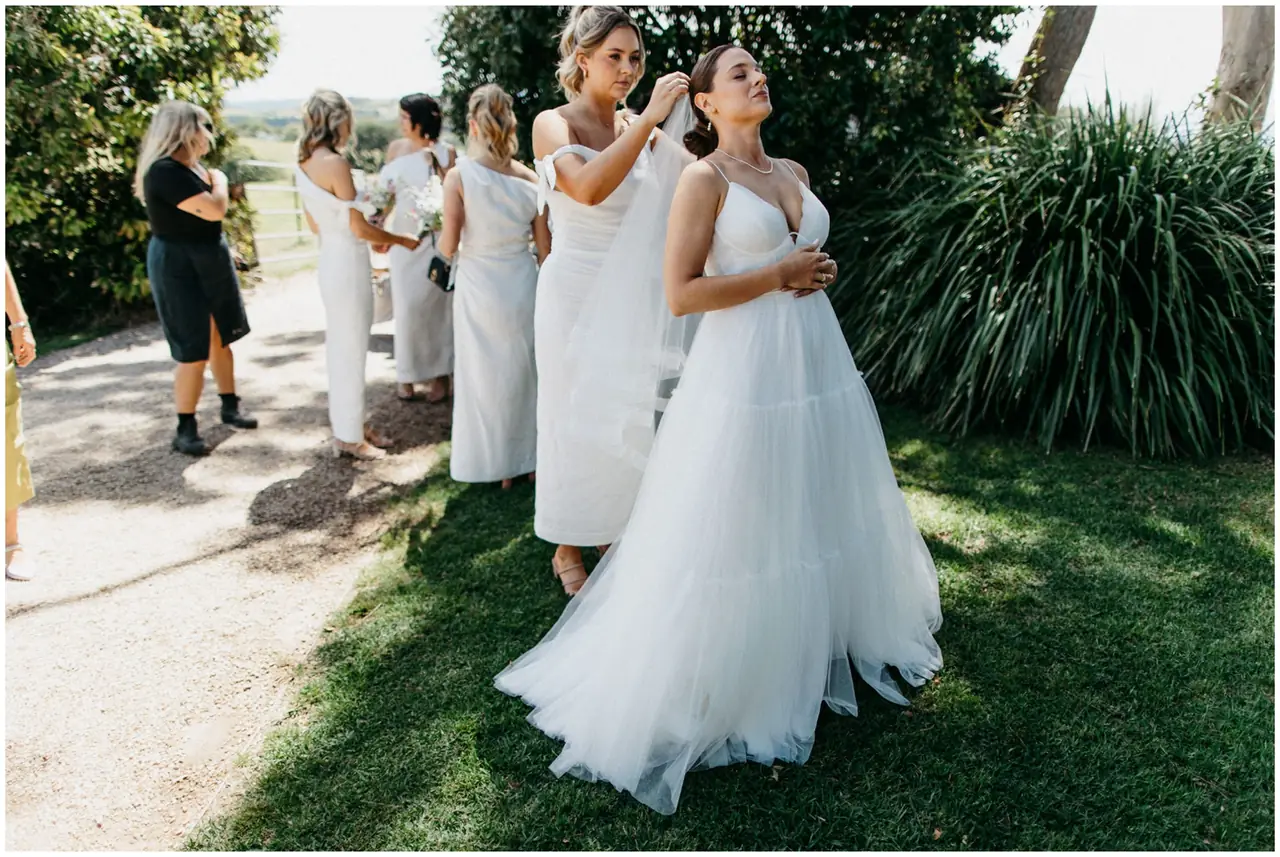 Marty & Nicola at Byron View Farm: The bride and attendants take a photograph together in the garden.