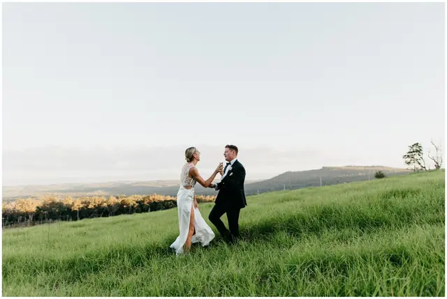 Ella & Jackson at The Woods: The couple walk together across a green paddock.